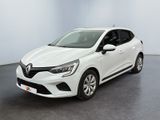 Une voiture blanche est garée dans une pièce au sol noir.
