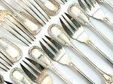 a lot of forks and spoons that are on a table