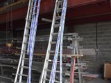 several ladders are leaning against a wall in a garage