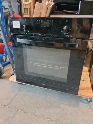 a black oven sitting on top of a cart in a warehouse