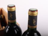 two bottles of wine sitting next to each other on a table