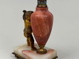 a pink vase sitting on top of a marble base
