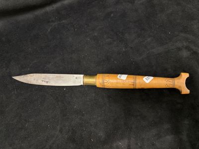 un gros plan d'un couteau à manche en bois posé sur un tissu noir