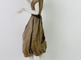 mannequin dressed in a brown dress with a purse on a stand