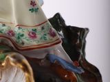 a figurine of a woman sitting on top of a horse