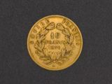 a close up of a gold coin on a black surface