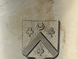 a silver plate with a coat of arms and a cross on it
