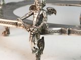 a silver plate with a statue of a woman holding a sword