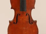 an old violin hanging from a string on a wall