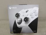 la boîte d'une manette Xbox blanche posée sur un canapé