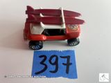 une petite voiture rouge avec une planche de surf posée dessus