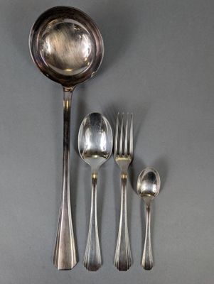 une cuillère, une fourchette, une cuillère et un repose-cuillère posés sur une table