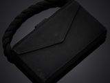 a black purse with a rope around it on a dark background