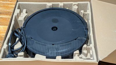 a box with a black object inside of it on a table
