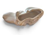 a white ceramic shoe shaped object on a white surface