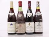 quatre bouteilles de vin sont alignées sur une surface blanche