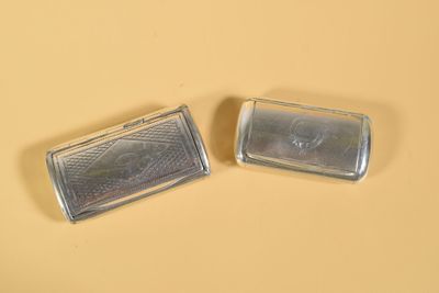 deux petits objets argentés posés sur une surface jaune