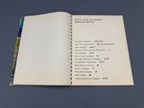 un livre ouvert posé sur une table, sur fond bleu