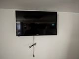 a flat screen tv mounted on the wall above a bed