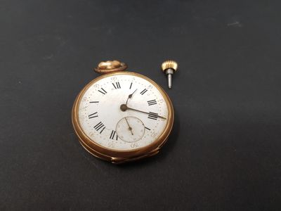 a small gold pocket watch with roman numerals on it
