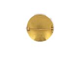 a close up of a gold metal object on a white surface