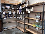 many shelves with bottles of alcohol on them in a store