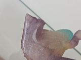 someone is holding a piece of amethorate on a glass table