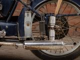 a blue motorcycle parked in front of a brick wall
