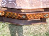 une table en bois avec un plateau en marbre posée sur l'herbe