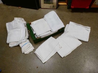beaucoup de serviettes blanches par terre, à côté d'une boîte verte