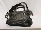black leather handbag on a white surface with a white background