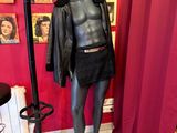 un mannequin dans une pièce où il y a des tableaux accrochés au mur