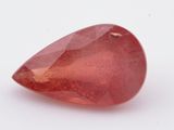 a close up of a red quartz stone on a white surface