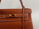 a brown leather handbag on a white background
