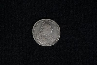 a close up of a silver coin on a black surface