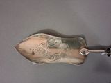 a silver spoon with a picture on it on a table