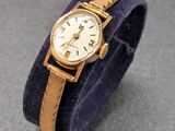 une image représentant une montre-bracelet avec un bracelet bleu et un cadran doré