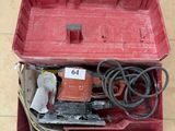 une boîte à outils rouge contenant des outils, posée sur un sol carrelé