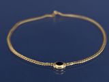 un bracelet en chaîne d'or orné d'une perle en pierre noire