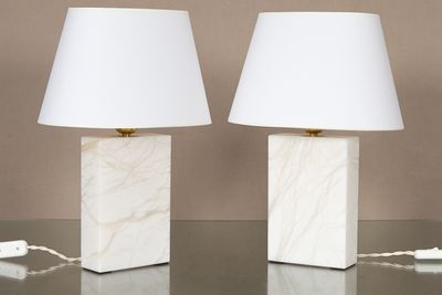 une paire de lampes en marbre blanc avec des abat-jours, posées sur une table