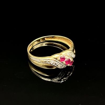 gros plan d'une bague en or avec une pierre en rubis