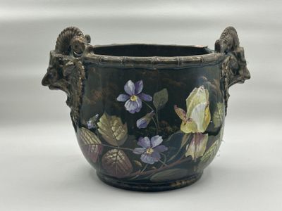 a vase with flowers painted on it sitting on a table