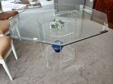 une table en verre sur laquelle trône un vase bleu, au milieu d'un salon