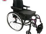 Le fauteuil roulant est noir et possède un siège et un repose-pieds violets.