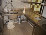 a kitchen with a sink and a metal counter top