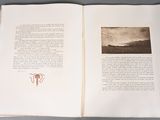 an open book with a picture of a mountain in the background