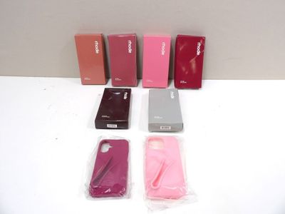 Plusieurs téléphones portables sont alignés sur une surface blanche