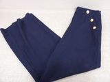 un gros plan sur un pantalon bleu posé sur une surface blanche