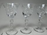 six wine glasses are lined up in a row on a table
