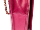 a close up of a pink purse with a chain hanging from it